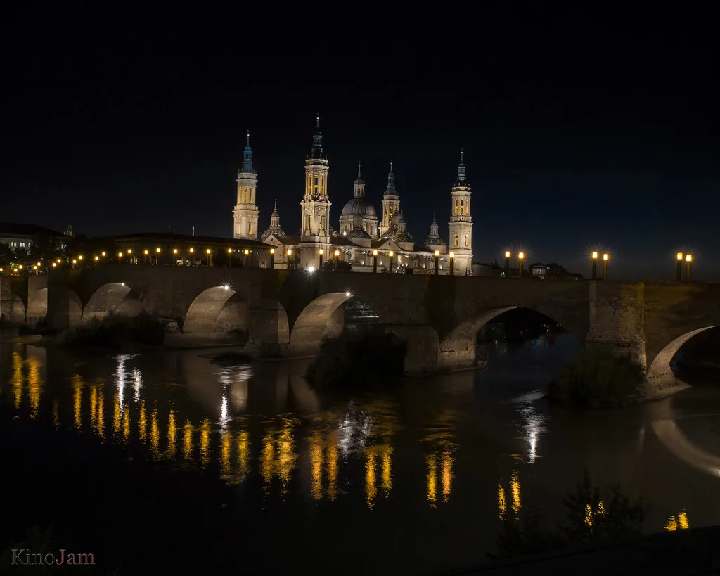 Venue view: Puente de Piedra and the Basílica del Pilar reflected in the Ebro at night, Zaragoza
