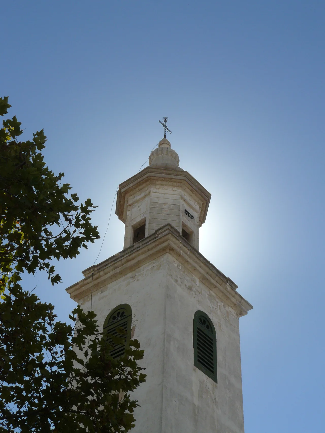Church tower with sun and a blue sky, Menorca